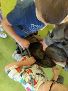 Chłopcy ciekawi zawartości plecaka