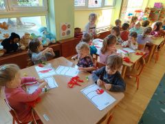 Dzieci wyklejają flagę paskami bibuły