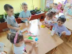 Dzieci tworzą grzechotkę z materiałów recyklingowych